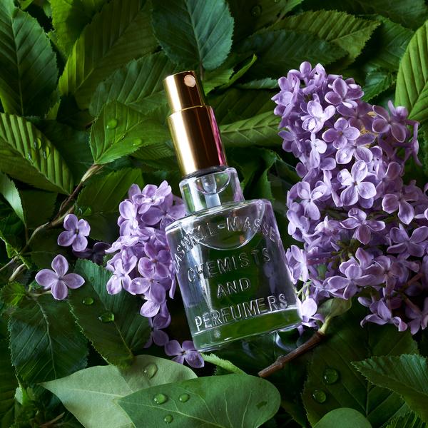 Apothecary perfume bottle on lilacs