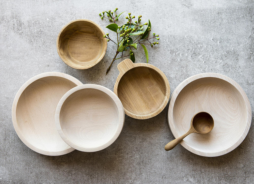 Wooden bowls in a stylish arrangement with foliage accent